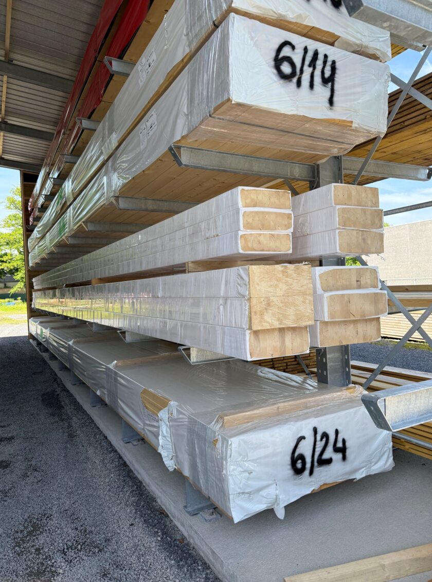 Verpackte Brettschichtholz-Balken aus Fichte mit sichtbarer Holzstruktur Gelagerte BSH Leimholzträger aus Fichte in verschiedenen Abmessungen Dachkonstruktion aus BSH Brettschichtholz bei einem Rohbau
