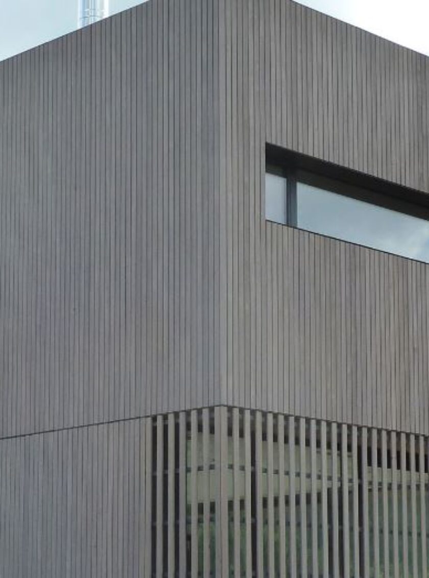 Zeitgenössisches Gebäude mit grauer Holzfassade aus schmalen vertikalen Lamellen