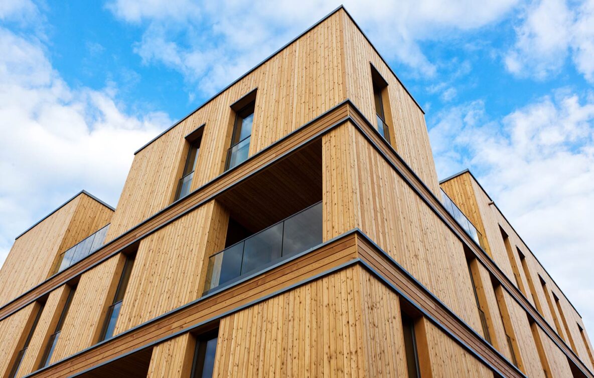 Mehrstöckiges Wohngebäude mit natürlicher Holzfassade und modernen Balkonen
