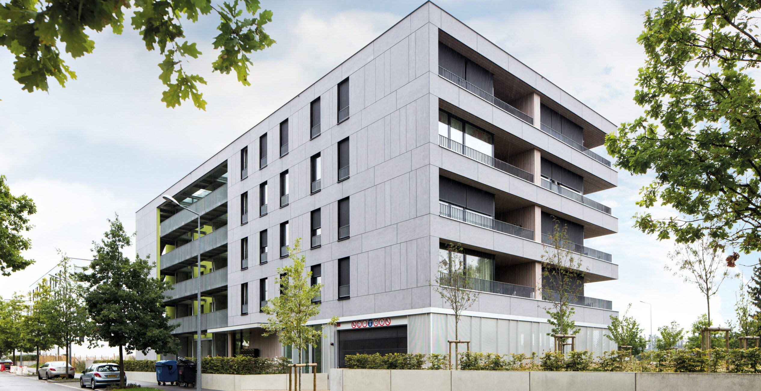 Moderne Hausfassade mit grauen Faserzementplatten und klaren geometrischen Linien