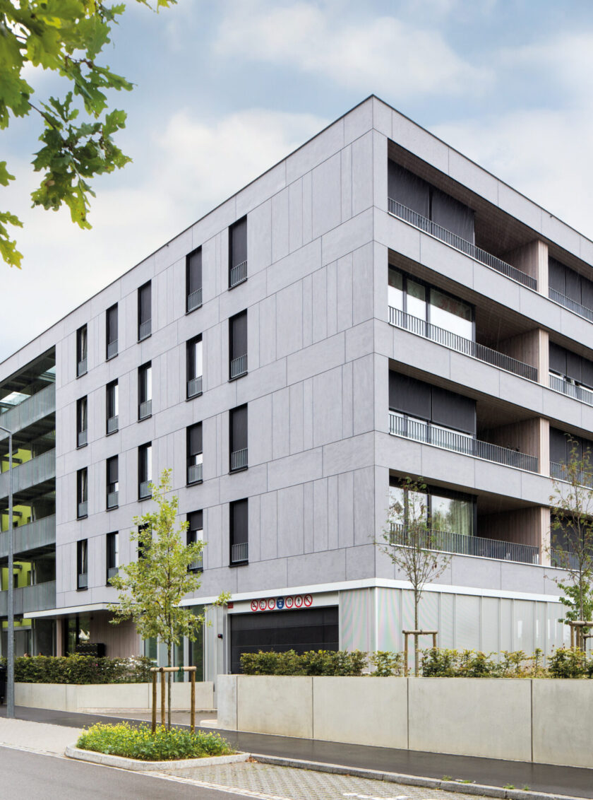 Moderne Hausfassade mit grauen Faserzementplatten und klaren geometrischen Linien