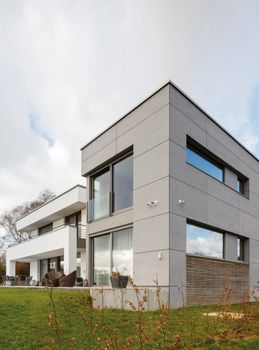 Moderne Hausfassade mit grauen Faserzementplatten und klaren geometrischen Linien