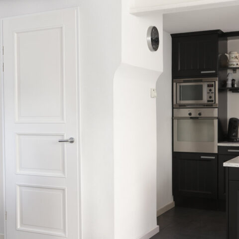 Moderne weiße Innentür mit horizontalen Fräsungen in minimalistischem Wohnraum