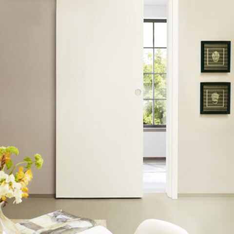 Minimalistische weiße Schiebetür mit sichtbarer Laufschiene in hellem Wohnraum