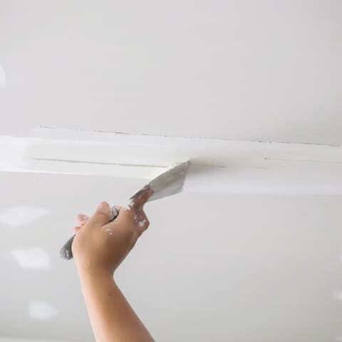 Verspachteln von Gipskartonplatten bei Trockenbauarbeiten an einer Decke
